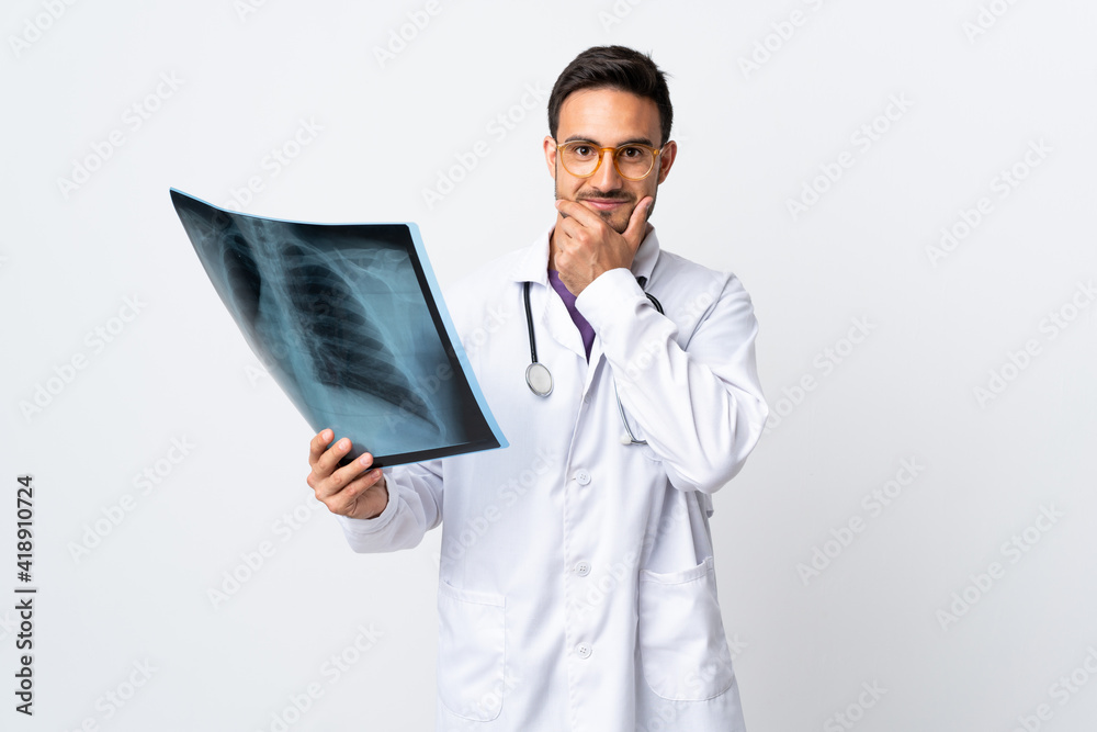 Young doctor man holding a radiography isolated on white background laughing Young doctor man holding a radiography isolated on white background laughing