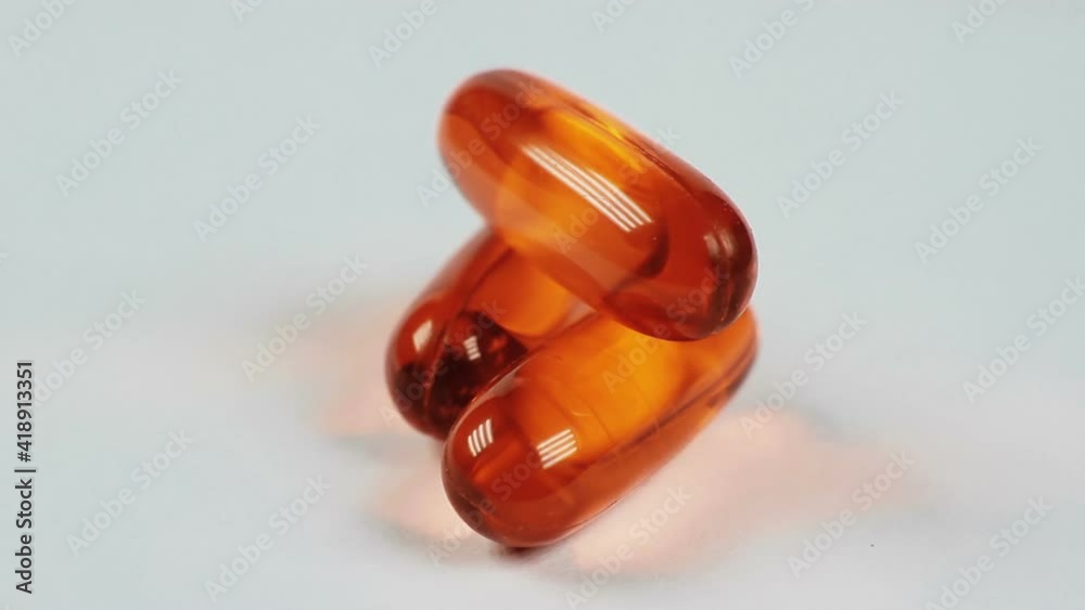 Vitamin capsules isolated on a white background macro closeup rotation. Vitamin capsules isolated on a white background macro closeup rotation.