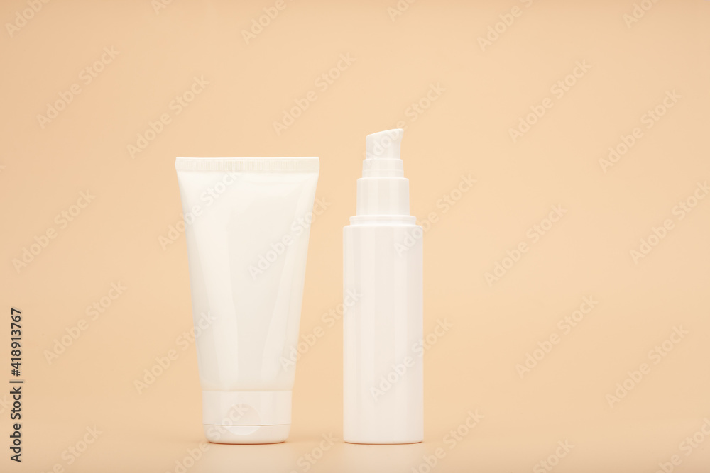 Moisturizing care for face and hands skin. Concept of skin care and beauty. Cream tubes against beige background with copy space Moisturizing care for face and hands skin. Concept of skin care and beauty. Cream tubes against beige background with copy space