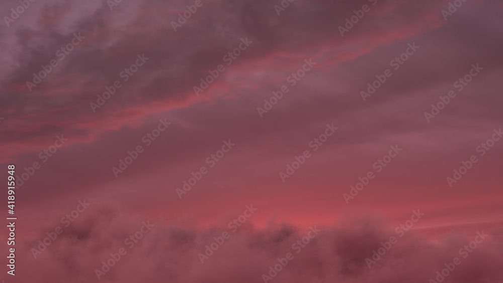 Obraz premium view to red sunset sky with fluffy clouds
