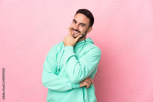 Young caucasian handsome man isolated on pink background happy and smiling