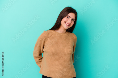 Young caucasian woman isolated on blue background happy, smiling and cheerful.