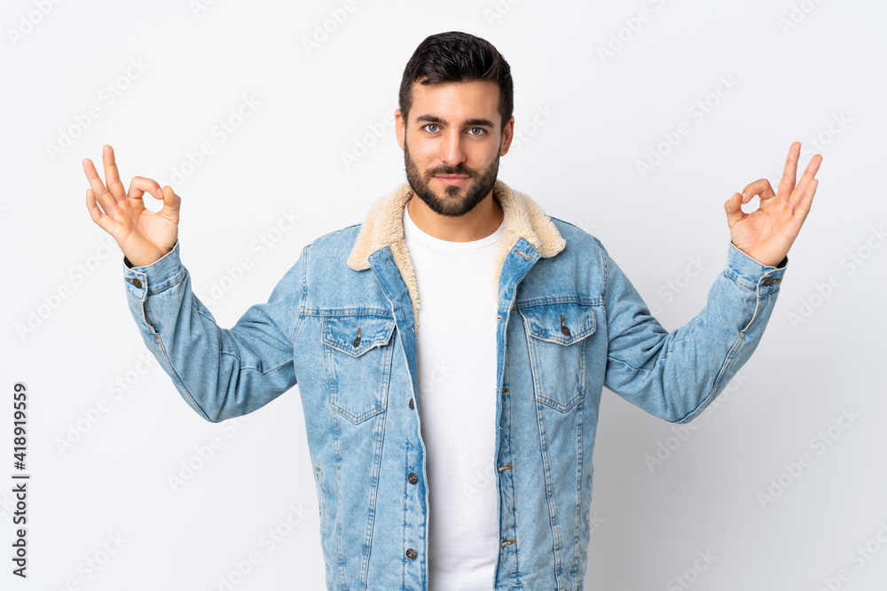 Young handsome man with beard isolated on white background in zen pose Young handsome man with beard isolated on white background in zen pose