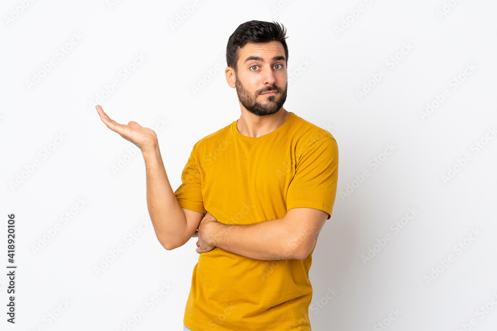 Young handsome man with beard isolated on white background having doubts