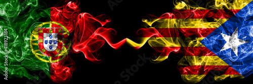 Portugal  Portuguese vs Catalonia  Catalan  Catalonian  Spain smoky mystic flags placed side by side. Thick colored silky abstract smoke flags.
