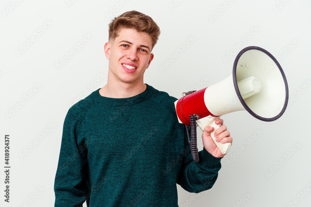 Young caucasian man holding a megaphone isolated on white background happy, smiling and cheerful. Young caucasian man holding a megaphone isolated on white background happy, smiling and cheerful.