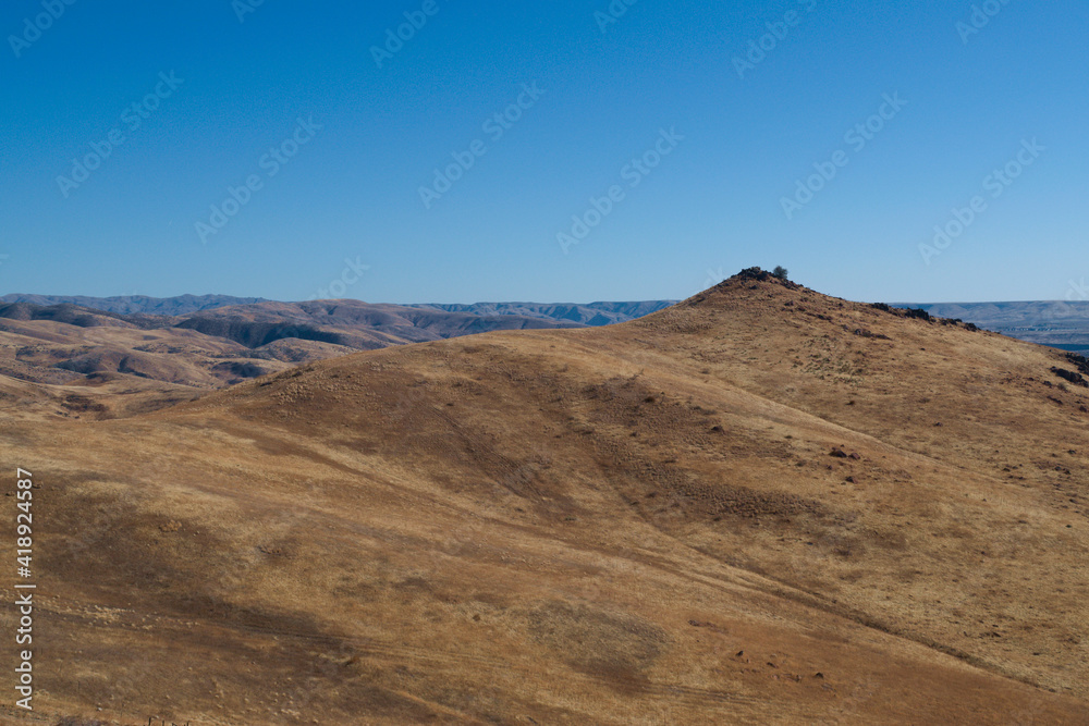 Desert hill in in front of vast desert landscape 
