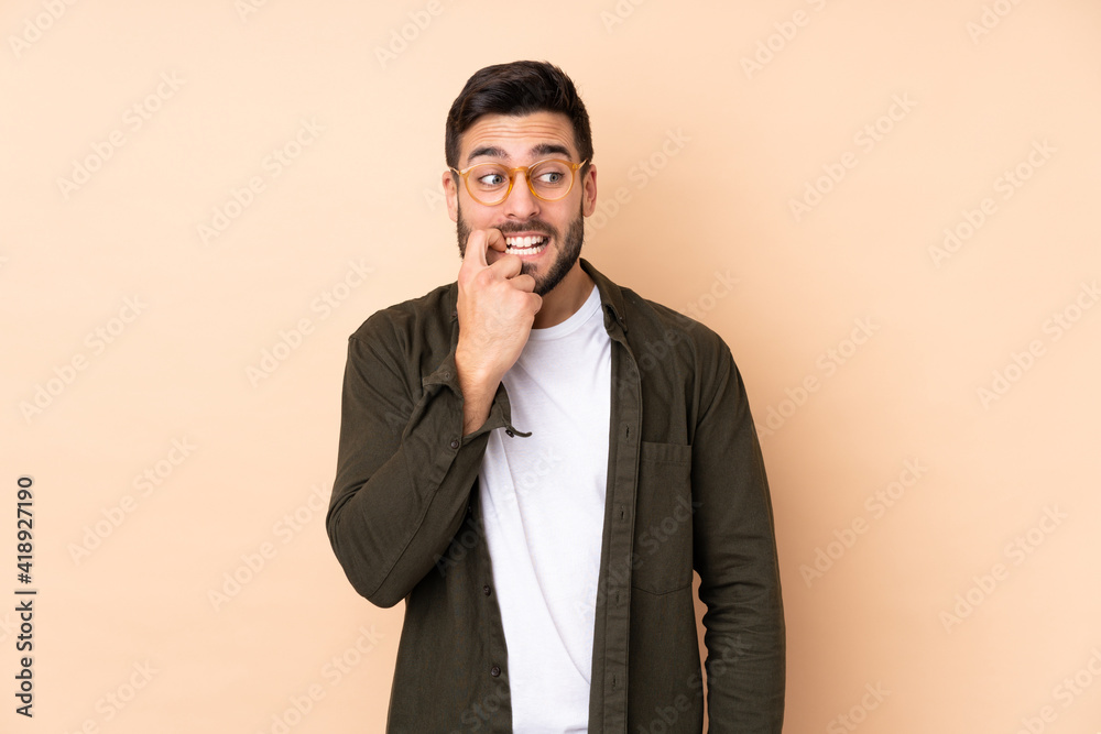 Caucasian handsome man isolated on beige background nervous and scared Caucasian handsome man isolated on beige background nervous and scared