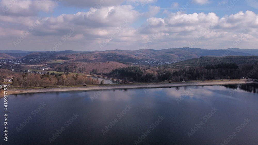 Aerial view over the dam wall to the middle hills in the Sauerland region