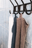 Three multicolored towels hanging on bathroom rack against blue tiles