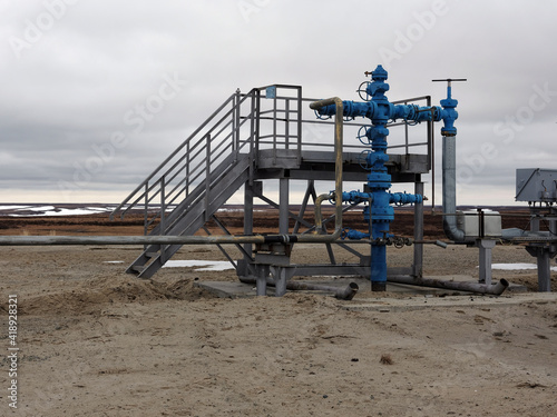 Oil and gas industry. Gas exploratory wells against the evening sky and clouds. Spring in the tundra.