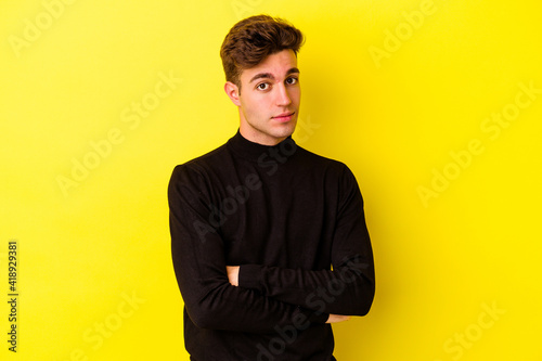 Young caucasian man isolated on yellow background unhappy looking in camera with sarcastic expression.