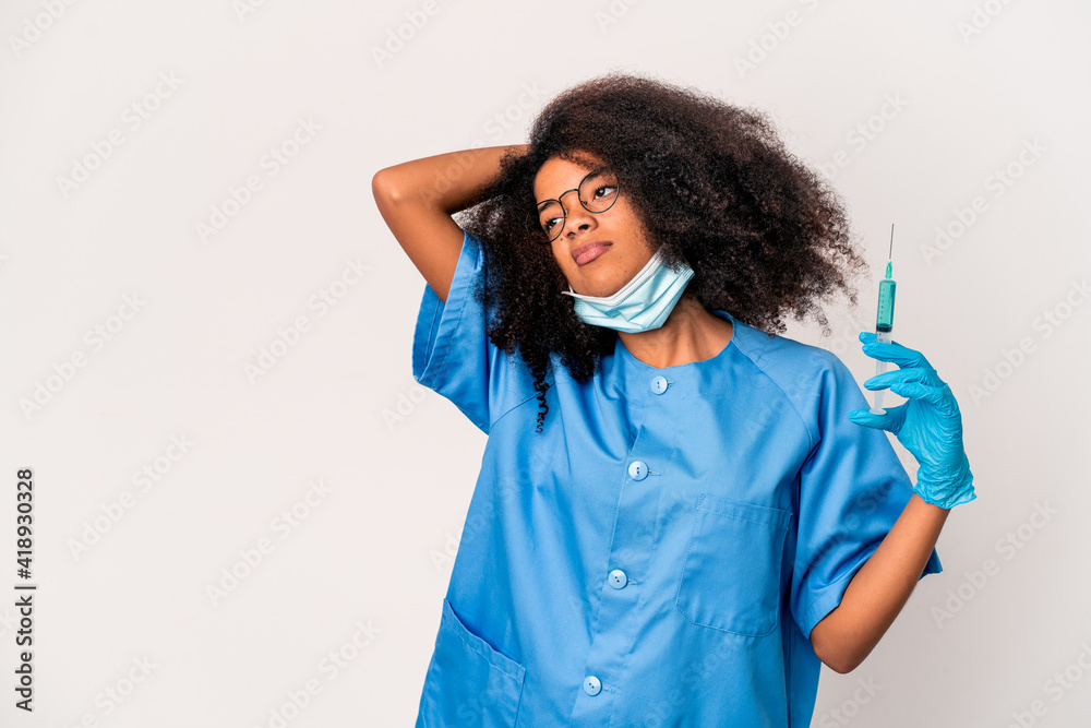Young african american curly doctor woman holding a syringe touching back of head, thinking and making a choice. Young african american curly doctor woman holding a syringe touching back of head, thinking and making a choice.