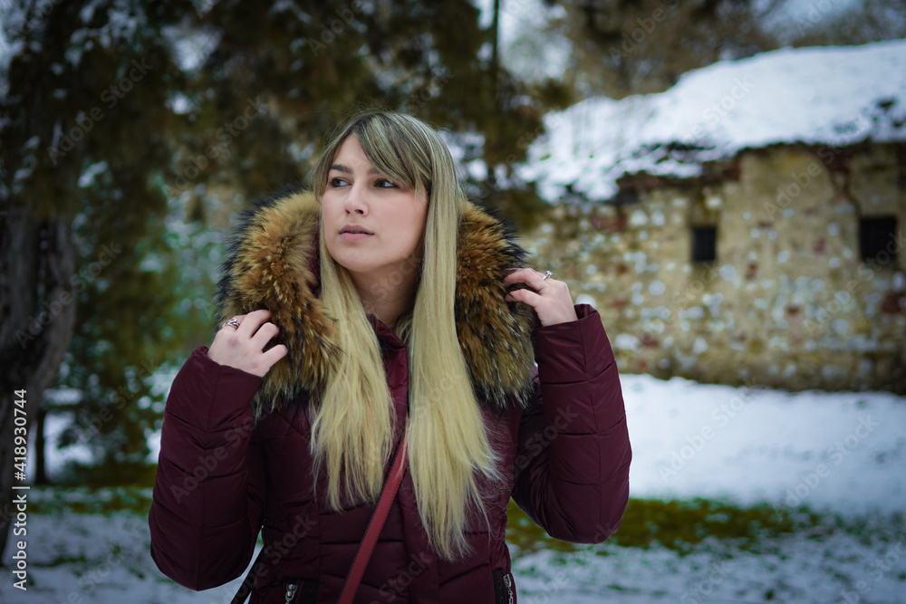 Beautiful blonde girl walking in the park on snowy winters day. Beautiful blonde girl walking in the park on snowy winters day.