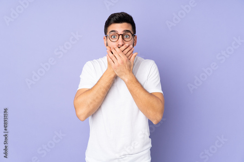 Caucasian handsome man over isolated background covering mouth with hands