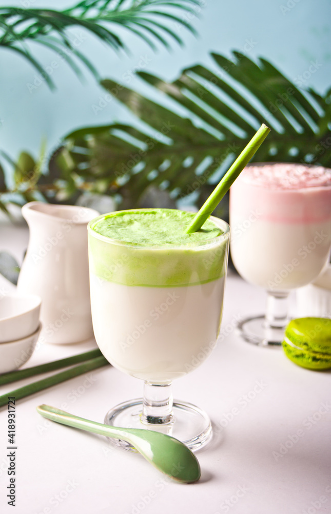 Dalgona Matcha and strawberry latte,creamy whipped matcha green tea and strawberry with plant on the background Dalgona Matcha and strawberry latte,creamy whipped matcha green tea and strawberry with plant on the background