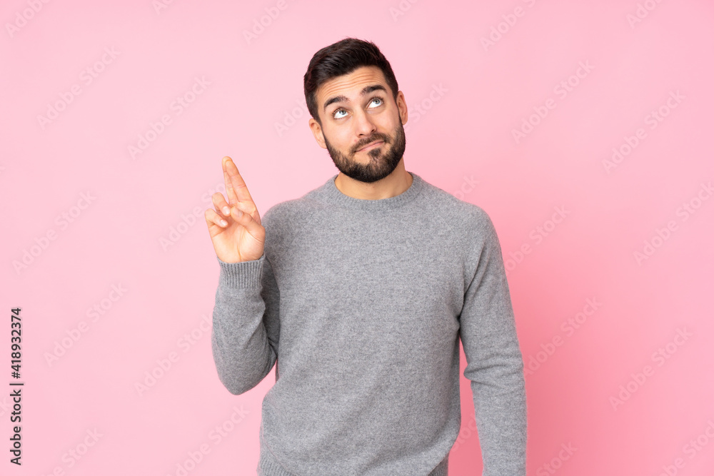 Caucasian handsome man over isolated background with fingers crossing and wishing the best Caucasian handsome man over isolated background with fingers crossing and wishing the best