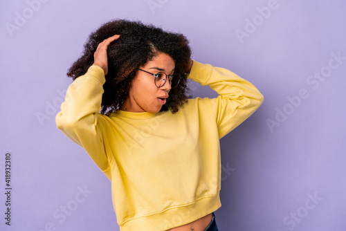 Young african american curly woman isolated on purple background screaming, very excited, passionate, satisfied with something. © Asier