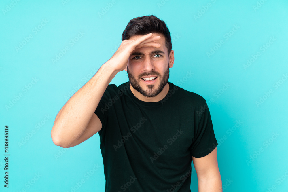 Caucasian handsome man isolated on blue background looking far away with hand to look something Caucasian handsome man isolated on blue background looking far away with hand to look something