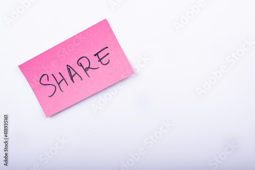 Share word written on a Pink color sticky note in a White background.