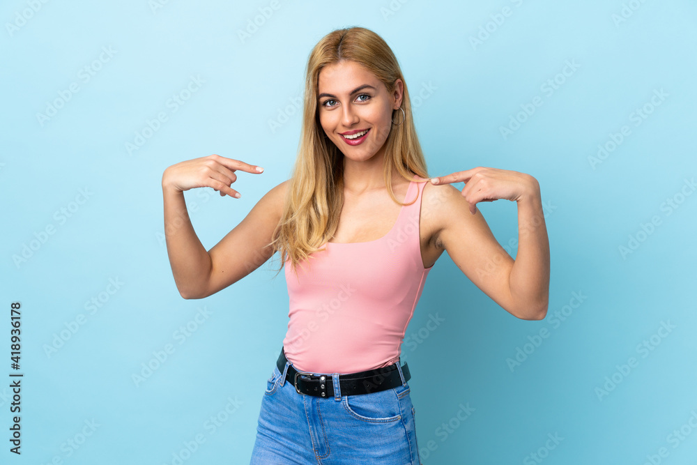 Fototapeta premium Young Uruguayan blonde woman over isolated blue background giving a thumbs up gesture