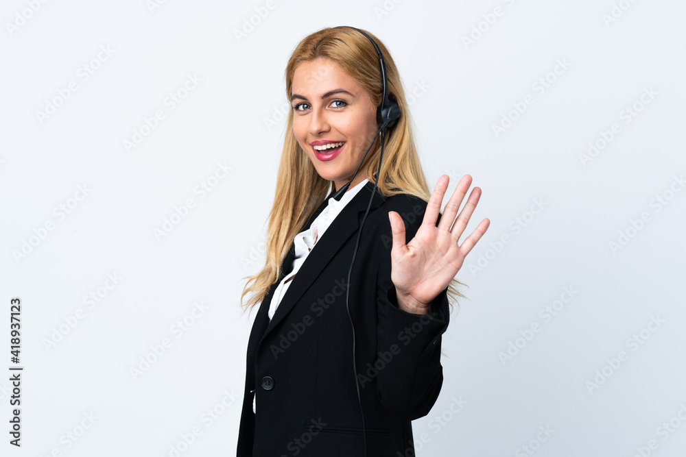 Young telemarketer woman over isolated white background saluting with hand with happy expression