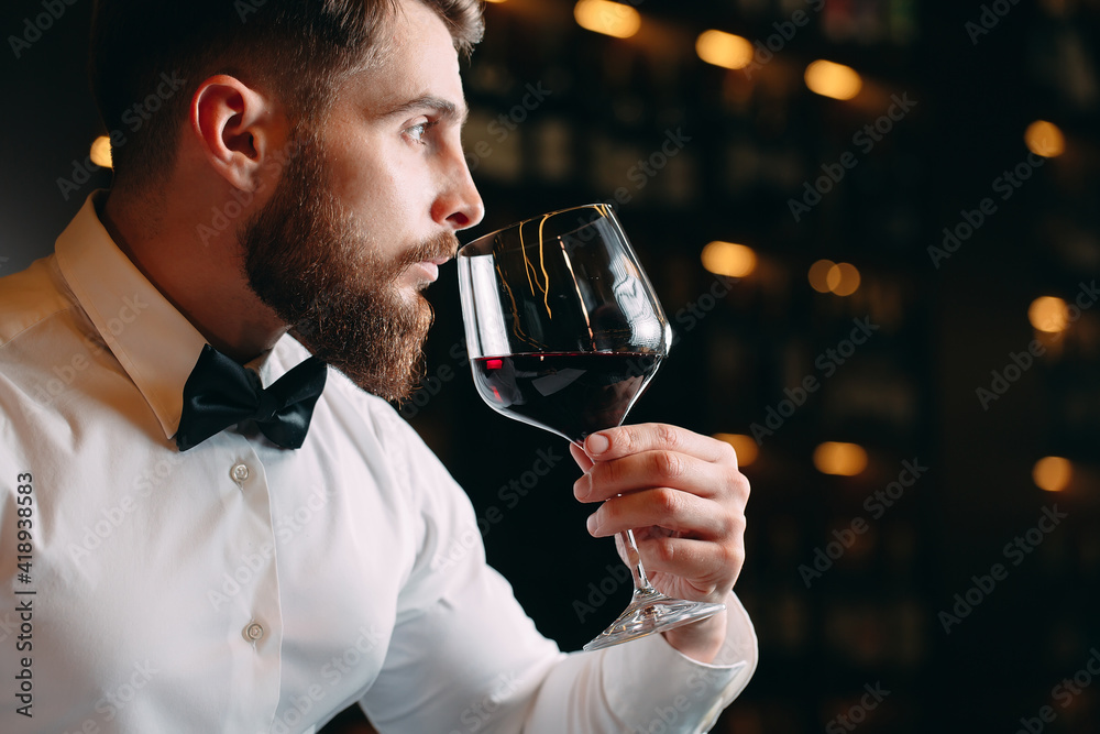 Close up of sommelier man sniffing wine in glass