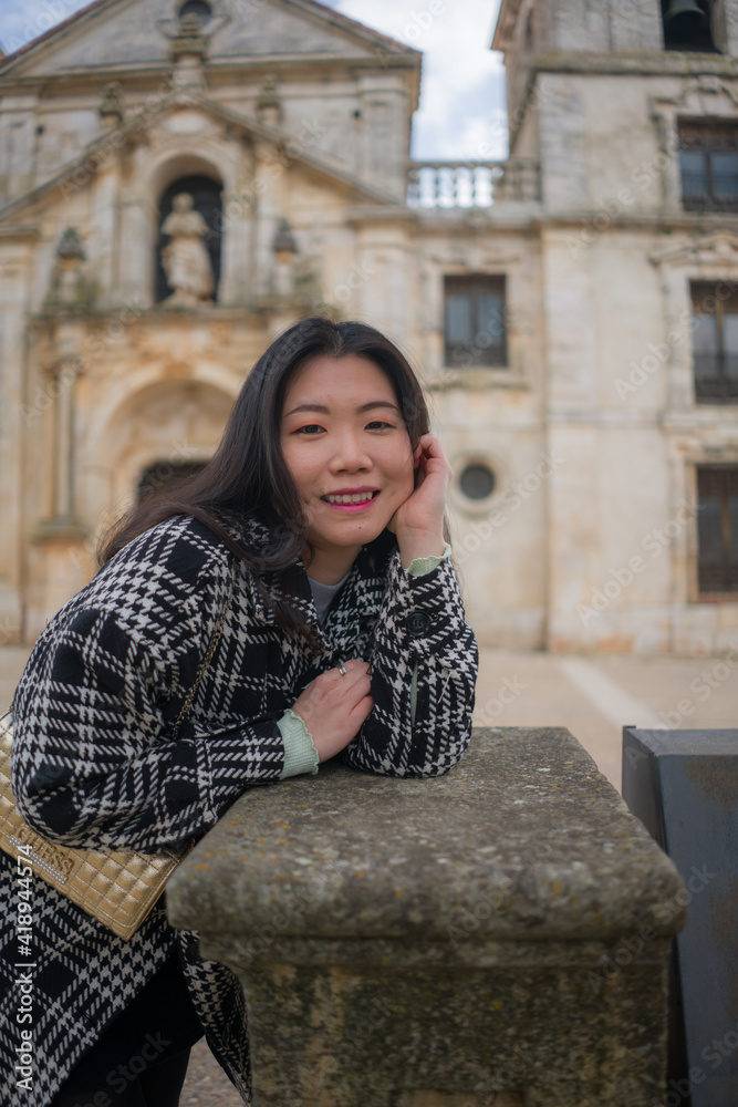 Asian woman enjoying holidays as tourist in Europe - lifestyle portrait of young happy and beautiful Korean girl in autumn coat touring the city relaxed and cheerful