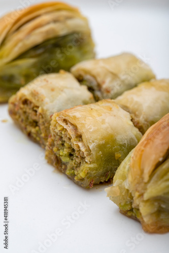 Baklava on a white plate. Serving pistachio and walnut baklava. Traditional Turkish, Greek and Arabic cuisine flavors