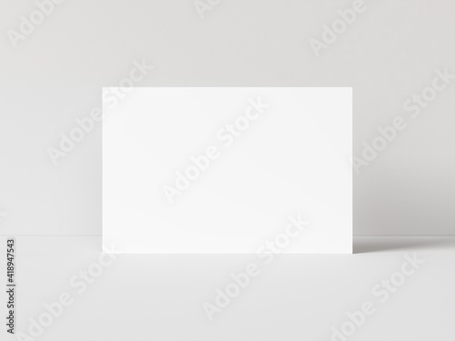 One blank horizontal rectangle poster template standing on white table with white background. 3D illustration © Washdog