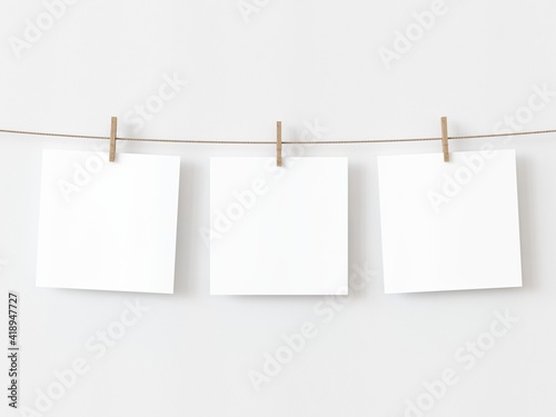 Set of three note paper cards hanging with wooden clip or clothespin on rope string peg isolated on white backgroun. 3D illustration photo