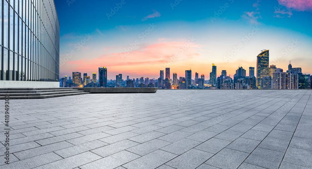 Empty square floor and city skyline with buildings at sunset in Shanghai.