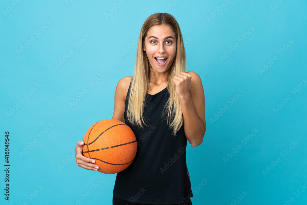 Young woman playing basketball  isolated on white background celebrating a victory in winner position
