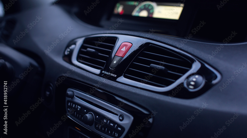 Ventilation vents with air flow deflectors and car emergency lights button.