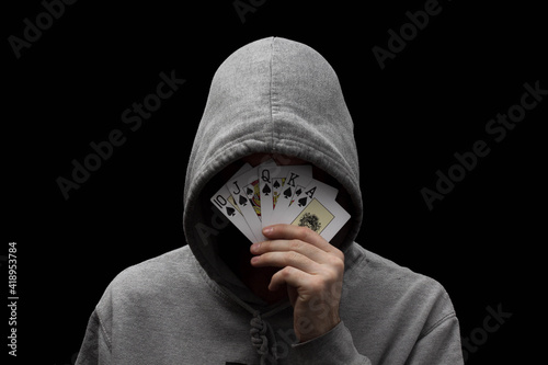 Man in hoodie with playing cards in his hand 