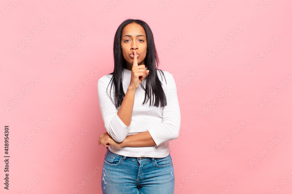 young black woman asking for silence and quiet, gesturing with finger in  front of mouth, saying shh or keeping a secret Stock Photo | Adobe Stock