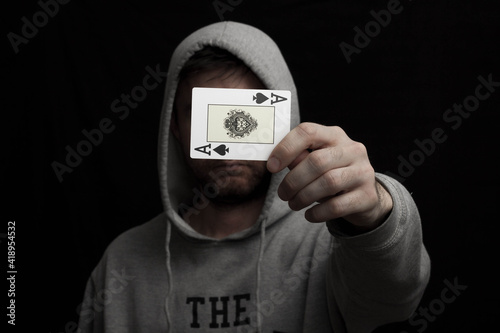 Man in hoodie with playing cards in his hand 