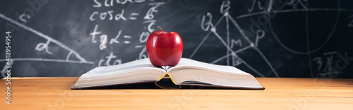 apple on book with blackborad background photo