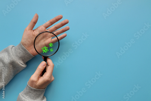 A person examines his hands under a magnifying glass and sees viruses. Fear of disease and infection. Protection and prevention of the disease photo