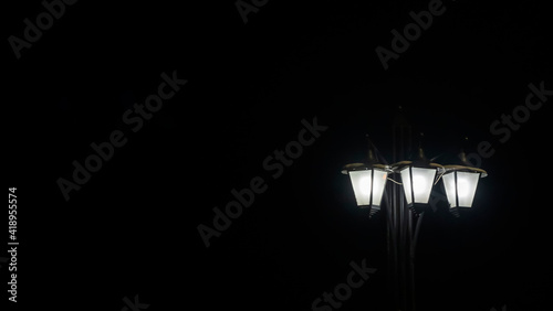 Street lanterns in dark. Night lights illuminate at the night. Image for design. Space for text.