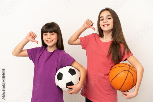 Little sisters playing football and basketball isolated on white background proud and self-satisfied in love yourself concept