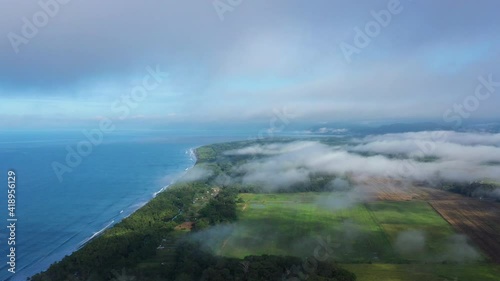 Clouds over farm fields along a tropical forest by the pacific ocean Costa Rica langostino photo