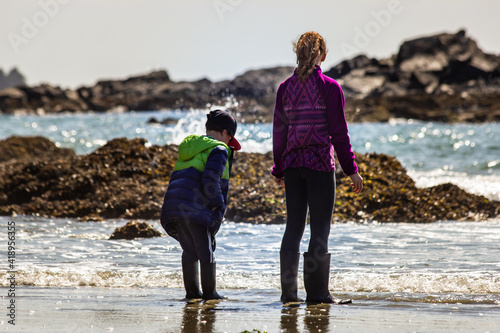 Children beach exploring at low tide while on vacation at Pacific Rim National Park near Tofino British Columbia. photo