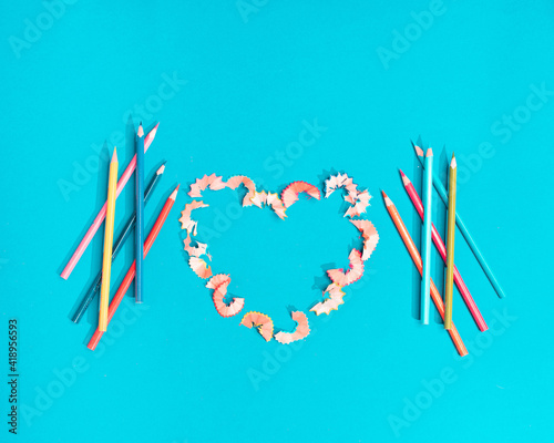 a heart made of crayons, a concept of love. Turquoise background