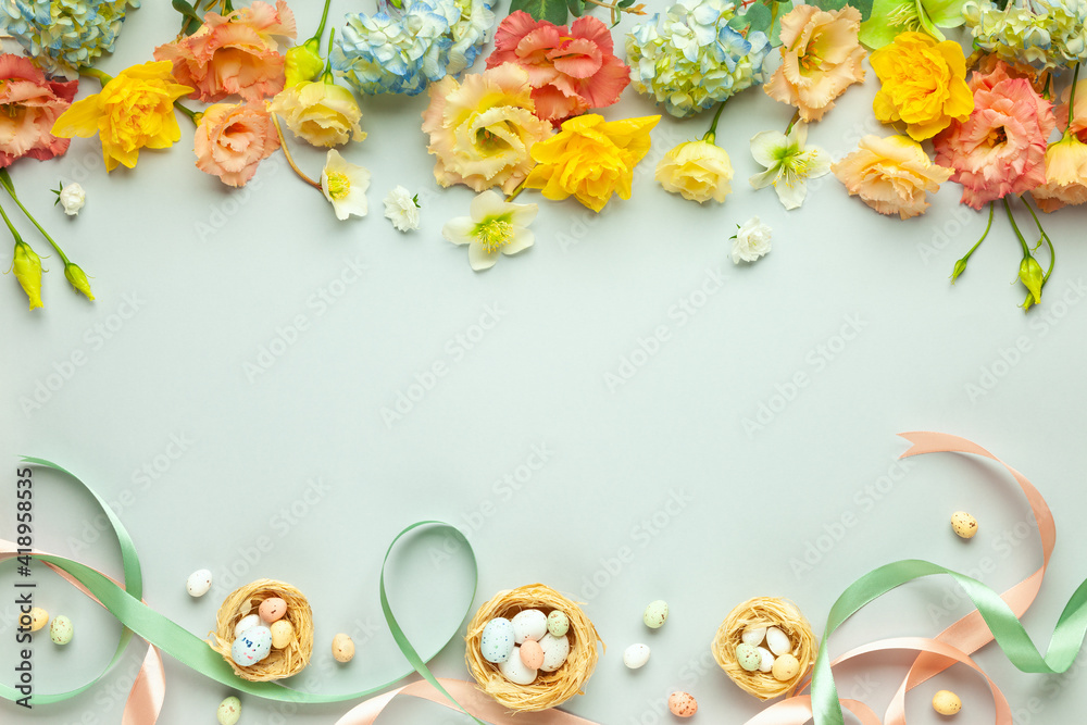 Fototapeta Happy Easter concept with easter eggs in nest and spring flowers. Easter background with copy space. Flat lay.