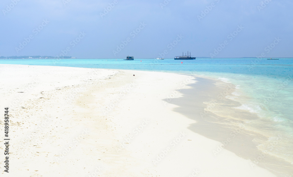 Paisaje deploy de  arena blanca y aguas turquesas en el atolón de Islas Maldivas, Océano índico