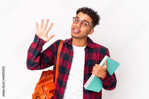 Young african american student curly man isolated holding books smiling cheerful showing number five with fingers.