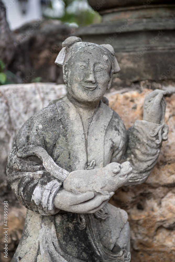 Beautiful asian statue with a farmer and his pig in the hands