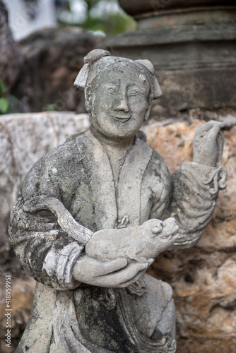 Beautiful asian statue with a farmer and his pig in the hands