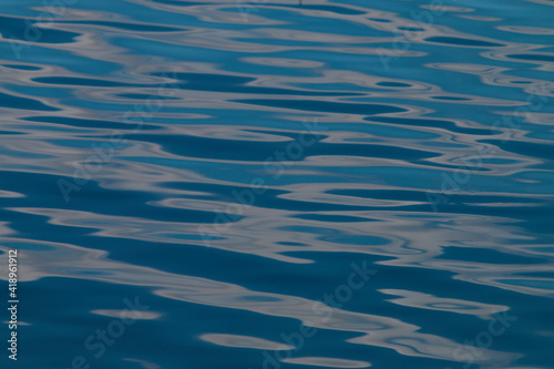 ripples and reflections on blue water